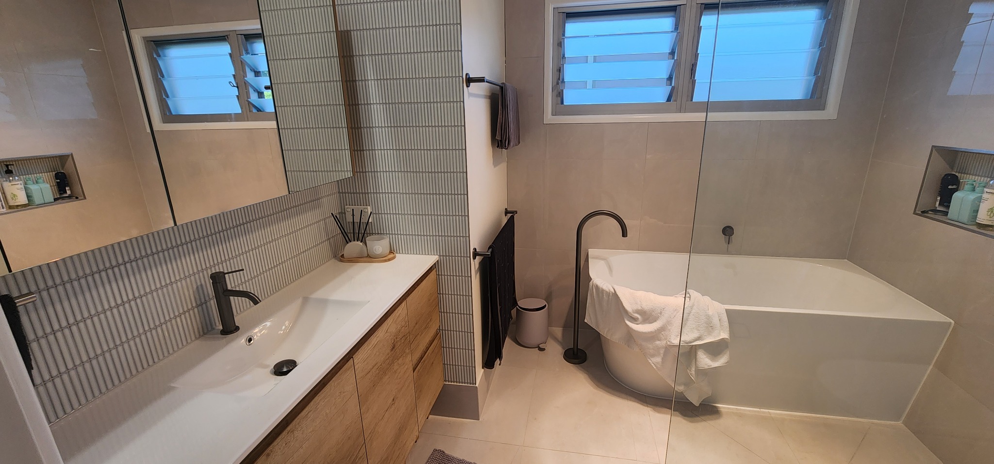 Bathroom with tiled vanity, bath and vertical feature tiles