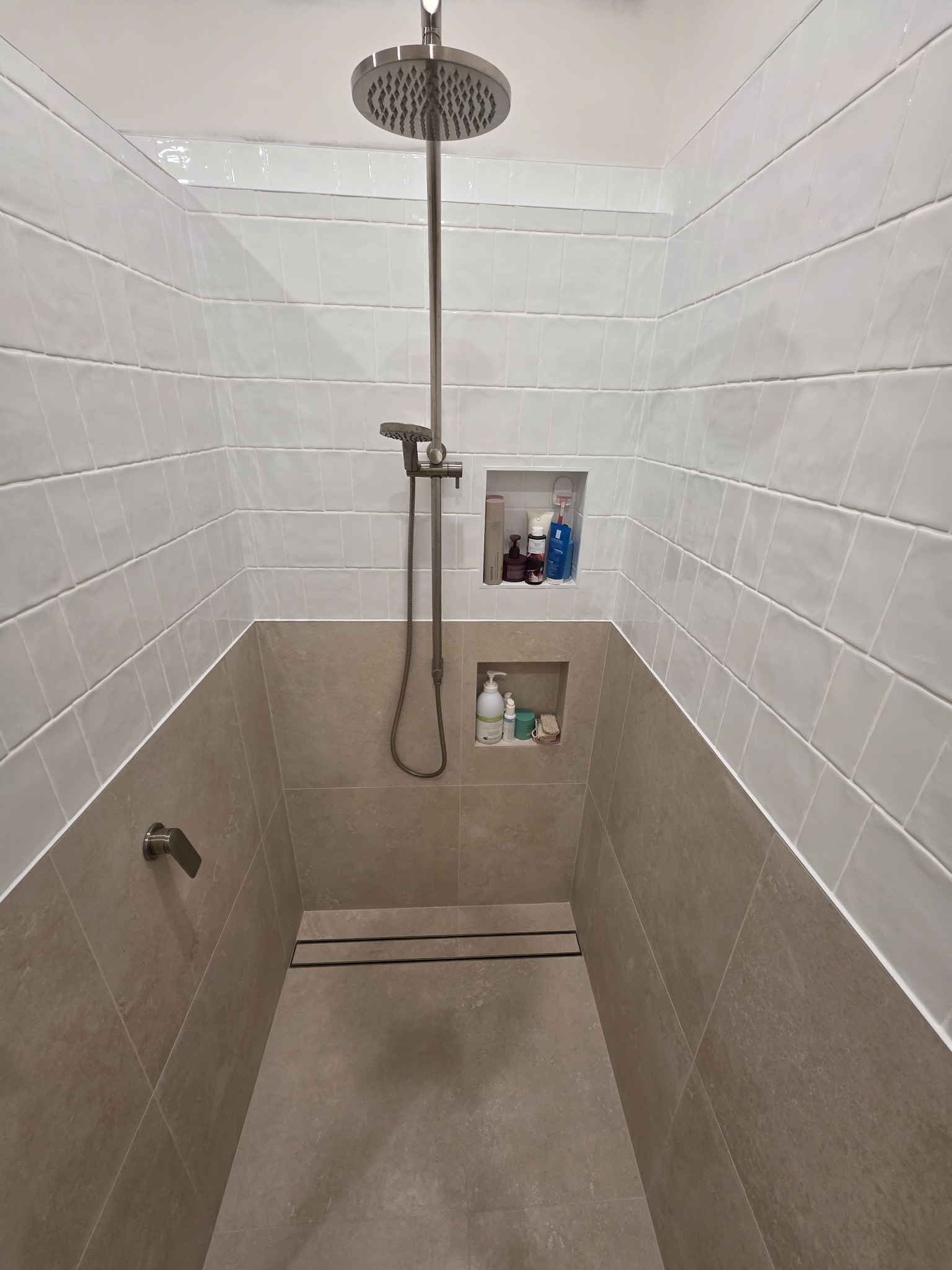 Walk-in shower with stacked subway tiles and dual niches
